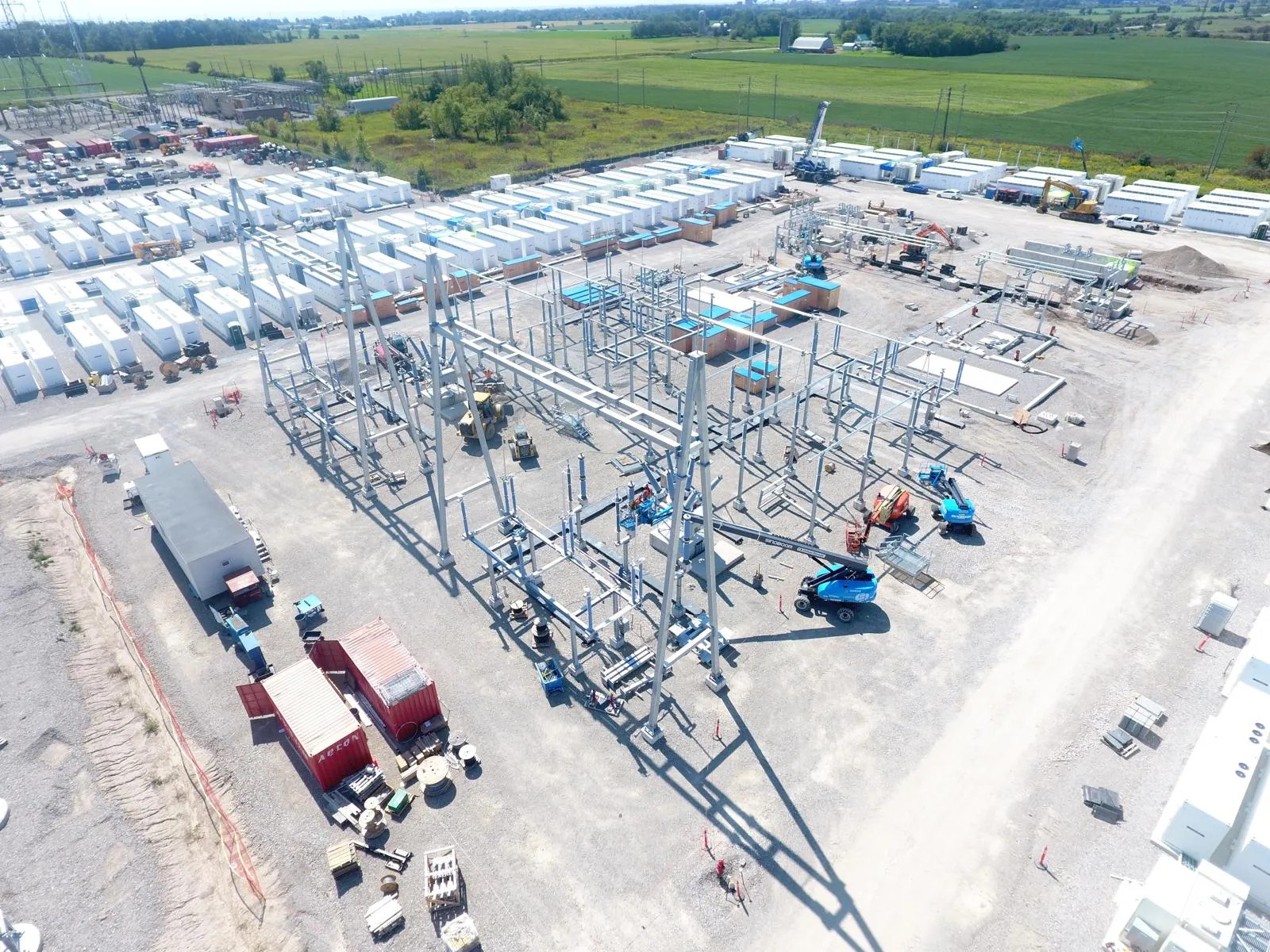 Aerial view of a utility substation under construction with fabricated steel A-frames, bus supports and lightning masts.